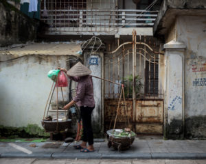 Street Hawker Carrying Large Pots On Stick