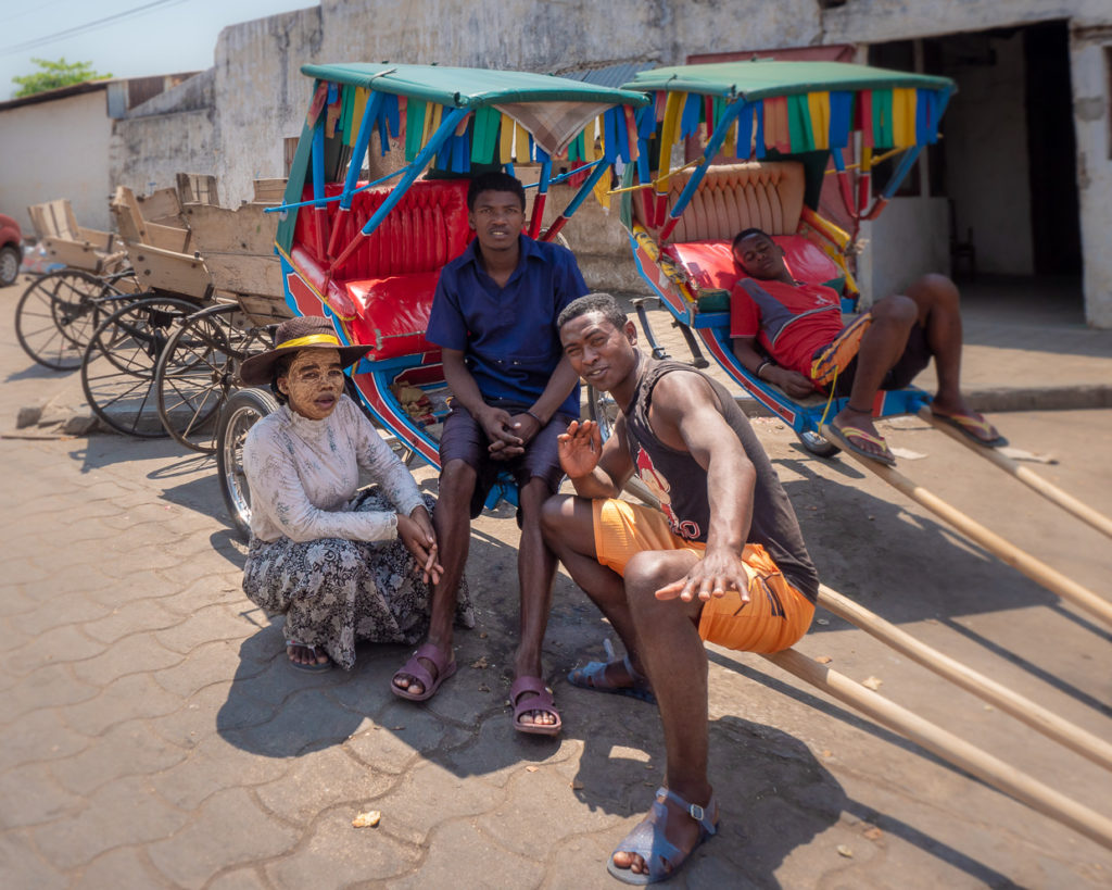 People In Front Of Colorful RIckshaws At Mahajanga in Madagascar