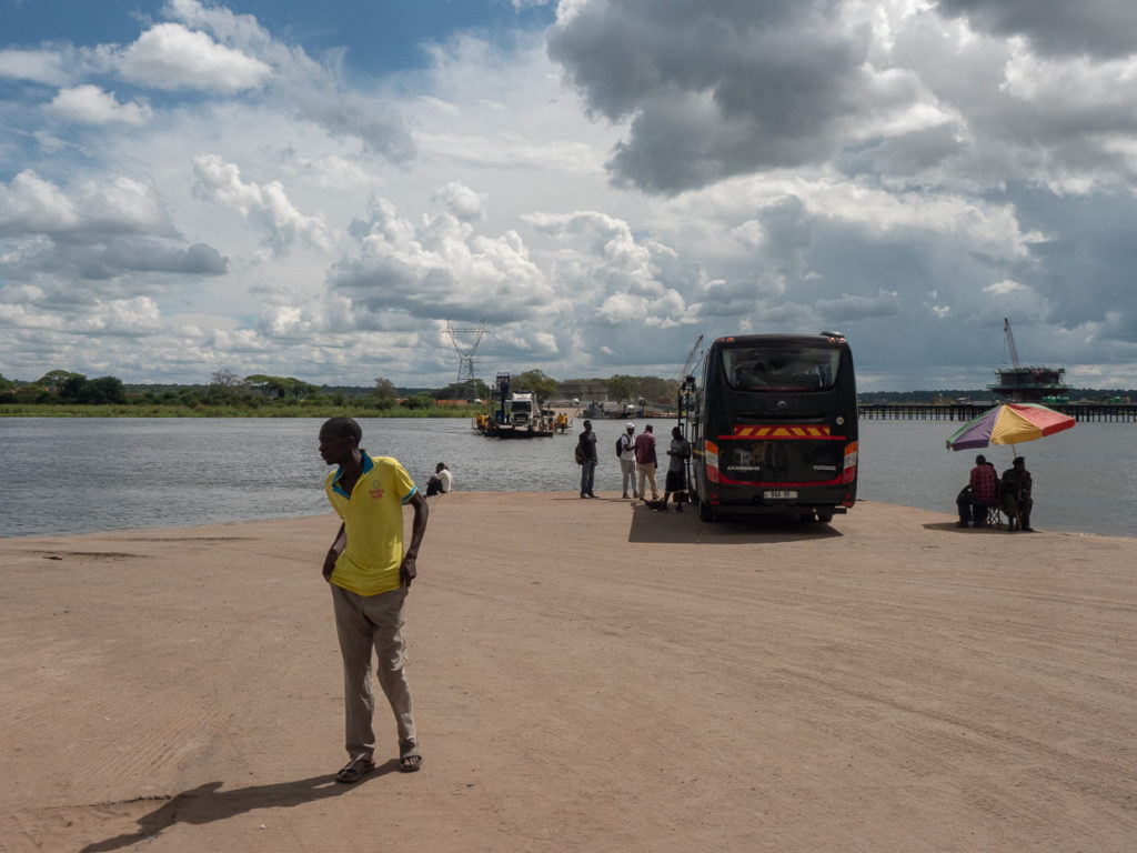 Kazungula Ferry approaching from Kasane Botswana to Zambia as people and buses await