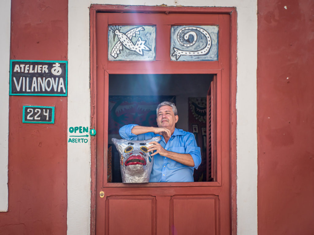 Artist Sérgio Vilanova in the windowsill of his studio with bull's head