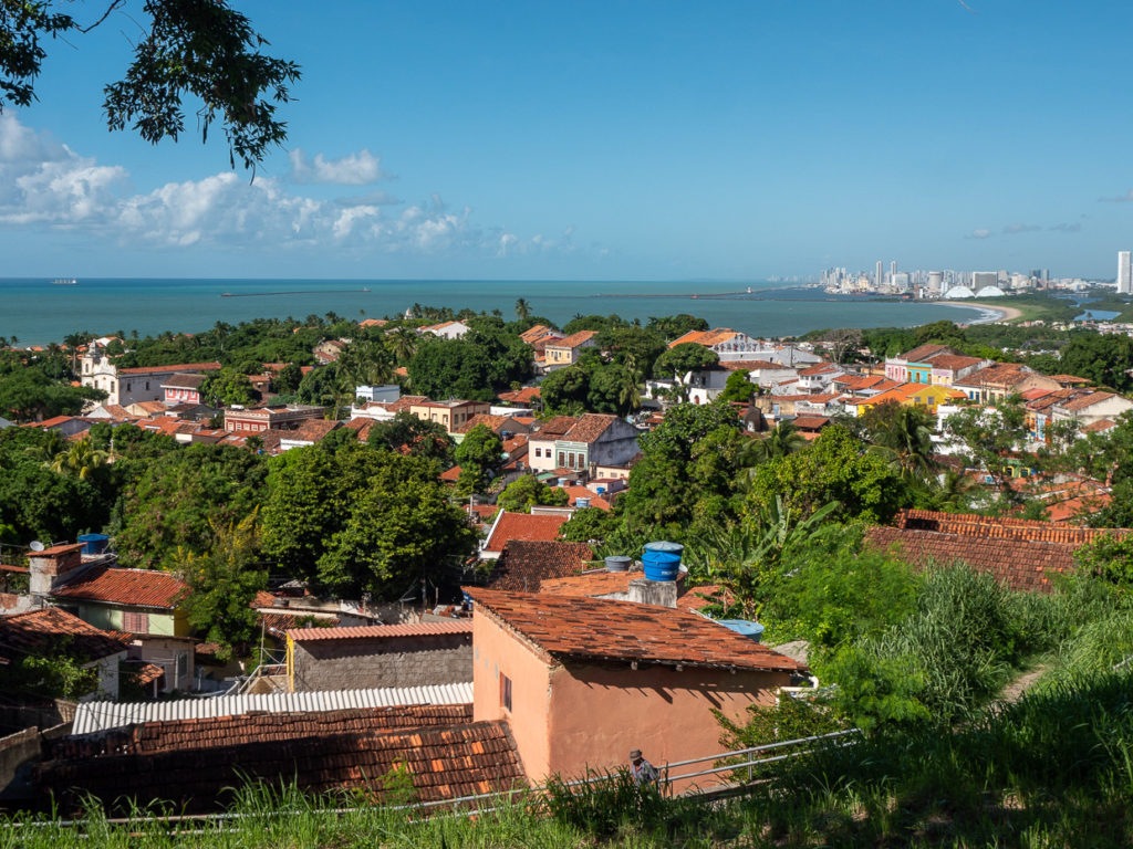 Bird’s eye view of historic Olinda, its terra cotta roofs framed in greenery, eventually giving way to the beaches and city spires of nearby Recife