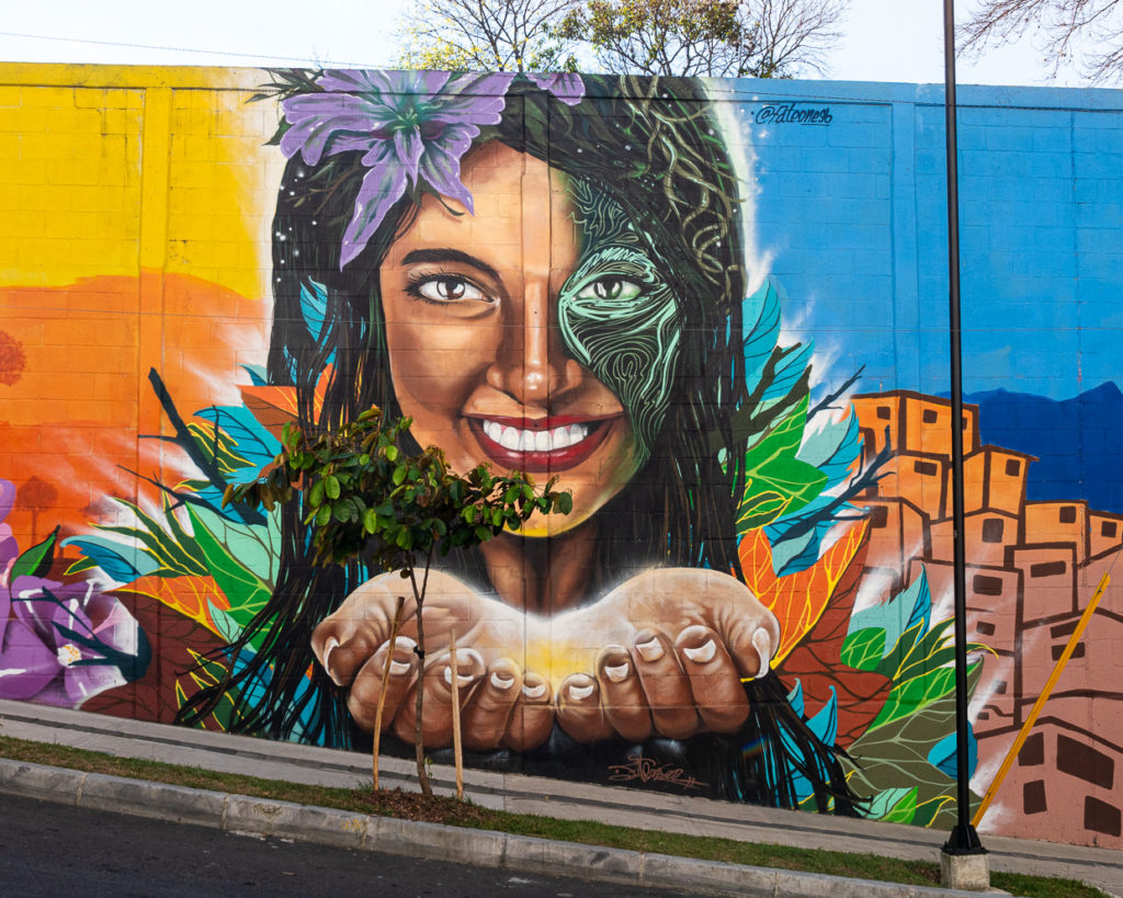 Street Art with Smiling Woman Hands Filled With Light Surrounded By Medellín 